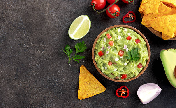 istock Mexican guacamole dip with avocado, tomatoes, chilli pepper, tortilla chips. Top view. Copy space 2232063186