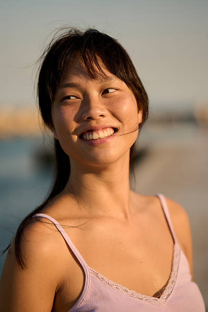 istock Young woman smiling and looking away at sunset 2232064352