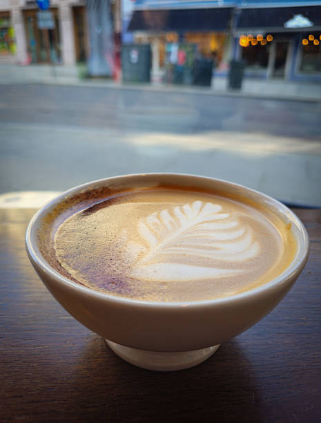 Warm latte art in a cozy cafe on a sunny day in a bustling city street