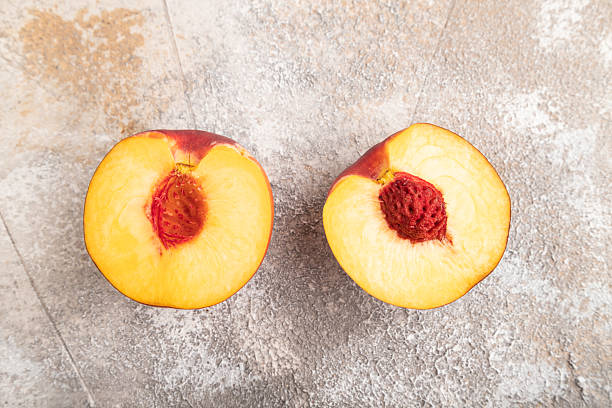 istock Peach Cut in half on brown concrete, Top view, close up 2232068387
