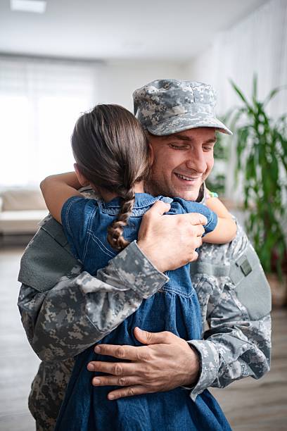 istock Soldier father is hugging his daughter at home 2232070388