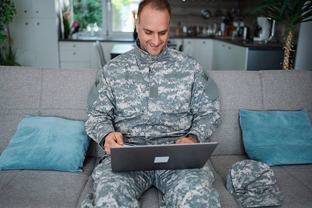 istock Soldier using laptop and credit card at home 2232070483