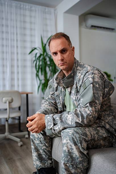 istock Soldier sitting on sofa looking sad at home 2232070533