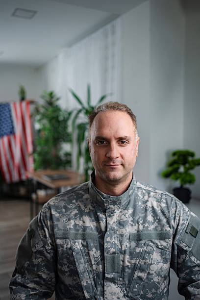 istock soldier looking at camera with United States flag in background 2232070568