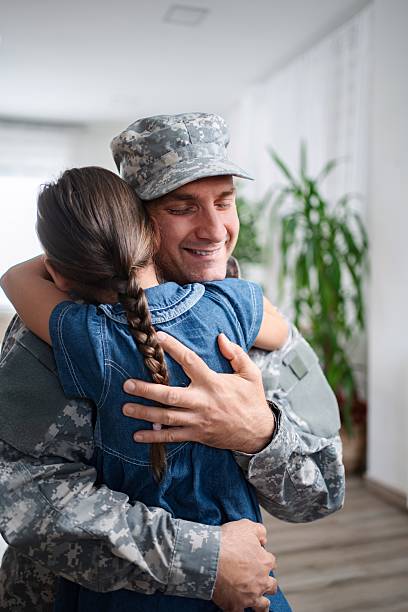 istock Soldier is hugging his daughter after returning home 2232070612