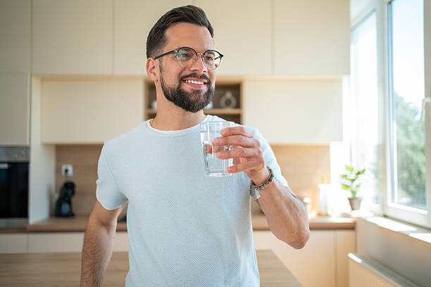 istock Smiling man drinking water in kitchen, healthy lifestyle 2232070794
