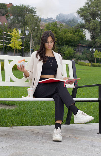 Indian student sitting on bench with books, representing dedication to study, higher education, and pursuit of knowledge as part of daily college lifestyle and personal growth.
