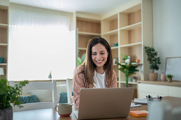 istock Happy woman working from home using laptop at the table 2232071993