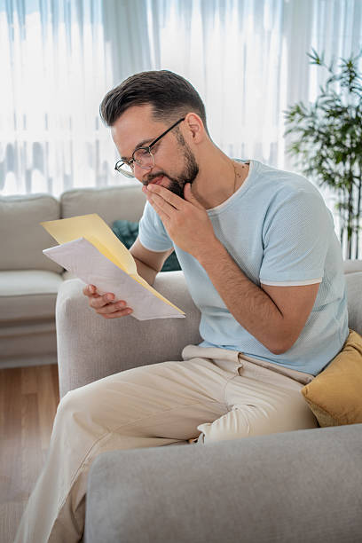 istock Worried man reading a letter at home 2232072967