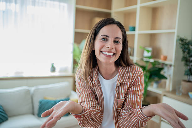 istock Young woman smiling and gesturing with open hands at home 2232075846