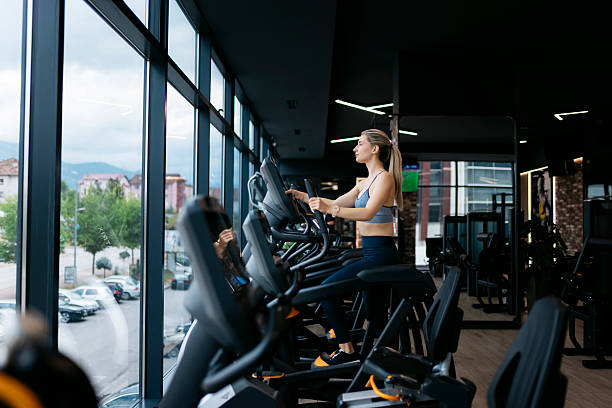 istock Young woman working out on elliptical trainer in modern gym 2232076757
