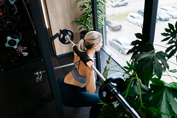 istock Young woman lifting weights in a gym with plants 2232076758