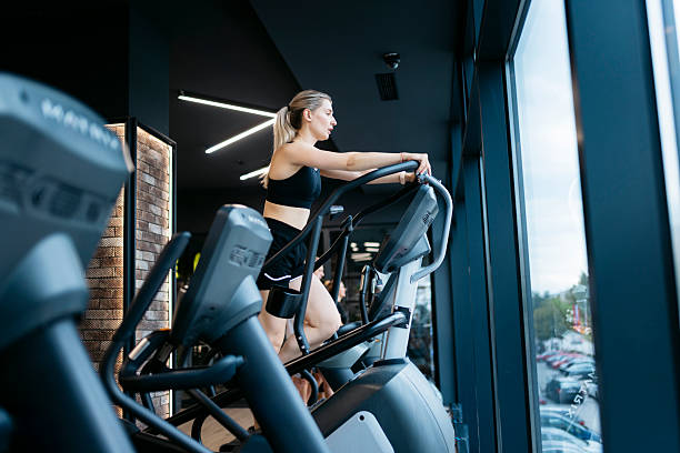 istock Young woman doing cardio exercise on stair climber machine in gym 2232076791