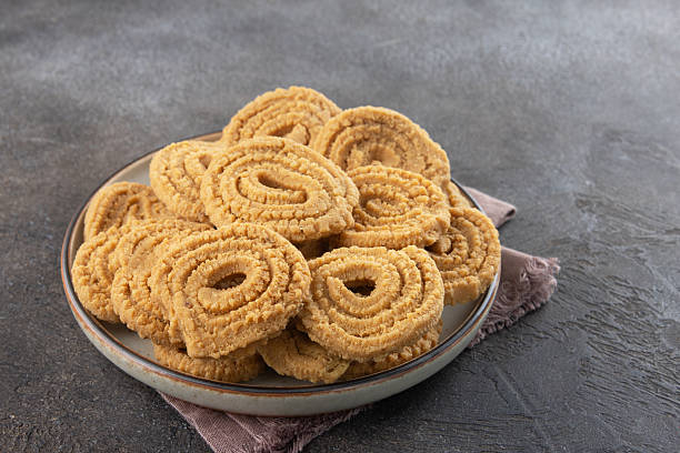 istock Indian chakli (murukku) snacks on gray background. Traditional crispy spiral Diwali snack. 2232077556