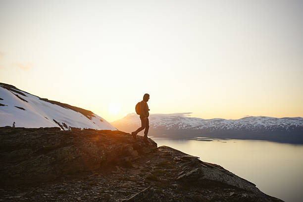 istock Young man stands on hill above lake at midnight 2232077872