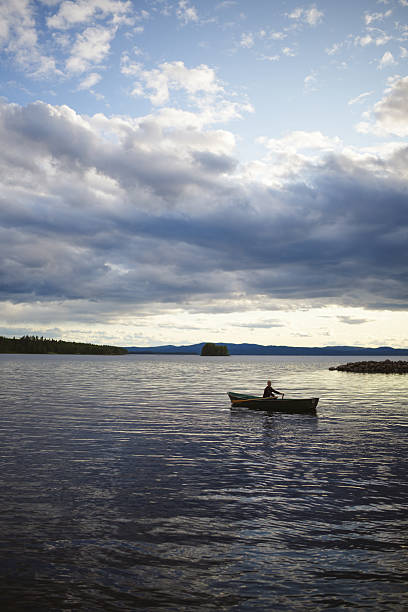 istock Young man rows boat on lake at sunset 2232078553