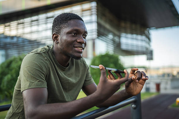 istock Young man sending a vocal message on his smart phone in the city 2232080385