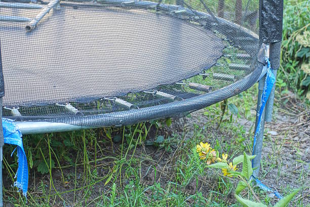 istock part of a big old torn trampoline stands on the ground 2232080998