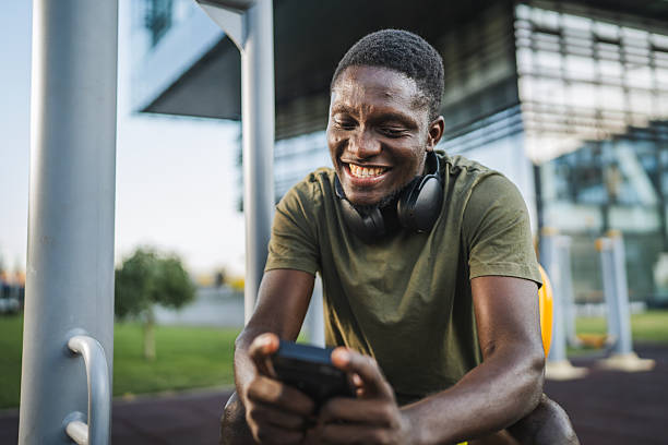 istock Smiling sportsman using phone app and resting after outdoor workout 2232081502