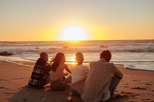 istock Friends watching golden sunset at beach: 2232084613