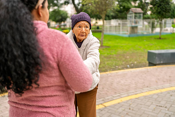istock Nurse assisting elderly woman walking in park 2232087253