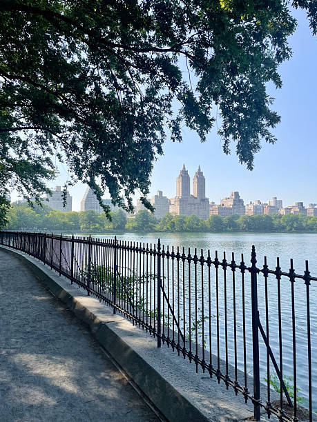 Historic Upper West Side building with reservoir water and trees in Central Park.