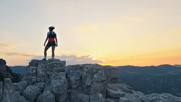 istock Runner Triumphantly Standing on Rocky Peak at Sunset 2232091397