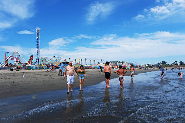 Virginia Beach, Virginia, USA - April 13, 2024: Children play at an outdoor playground on the beach at JT’s Grommet Island Beach Park as their parents supervise their activities.