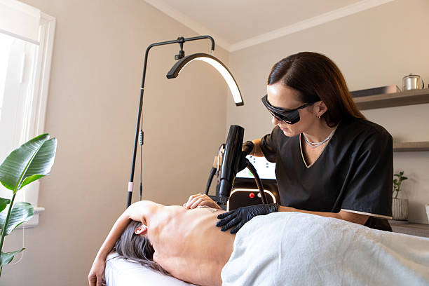 Female dermatologist applies laser and cutting-edge technology to a female patient to remove tattoo ink. Buenos Aires, Argentina.