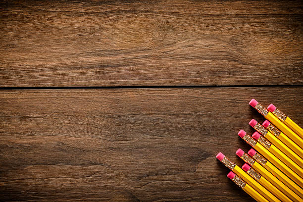 Back to school themes. Top view of pencils on wood table making a frame with copy space.