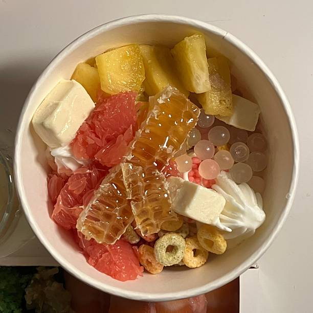 istock Swirled yogurt ice cream dessert served in a cup, smooth creamy texture with glossy surface, topped with fresh fruit pieces, highlighting its refreshing and inviting appearance in detail 2232123188