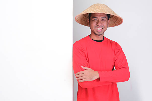 istock Indonesian farmer standing beside a blank board with happy confident expression 2232124223