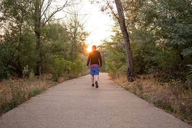 istock Young man walking on a path at sunset in a park 2232126272