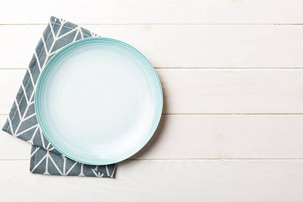 istock Top view on colored background empty round blue plate on tablecloth for food. Empty dish on napkin with space for your design 2232128743