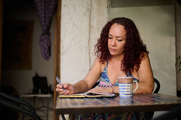 istock Focused Woman Writing Notes at a Cozy Outdoor Setting 2232129316