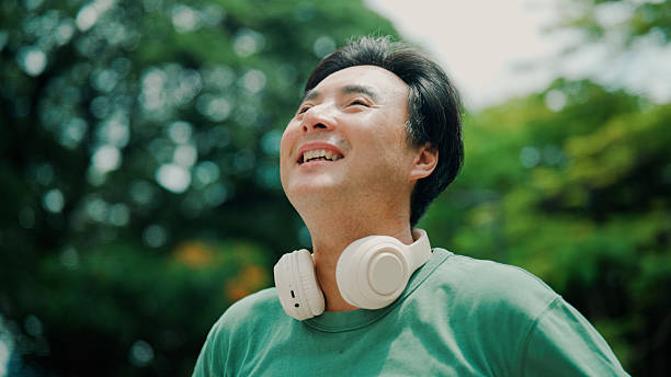 istock Middle-aged Asian man feeling refreshed after going outside to enjoy natural scenery. 2232130511