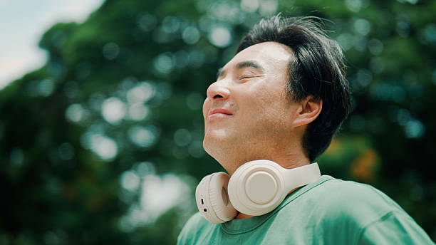 istock Middle-aged Asian man feeling refreshed after going outside to enjoy natural scenery. 2232130524