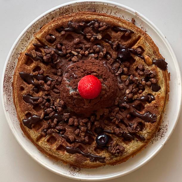 Crispy, golden waffles topped with creamy ice cream, creating a perfect balance of warm and cold, crunchy and smooth. A delightful dessert or breakfast treat, with toppings like fruits or syrup.