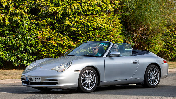Whittlebury,Norhants,UK - Aug 23rd 2025: 2002 silver Porsche 911 Carrera 4 classic  car driving on a British road