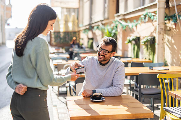 istock Customer making contactless payment with mobile phone in outdoor cafe 2232136366
