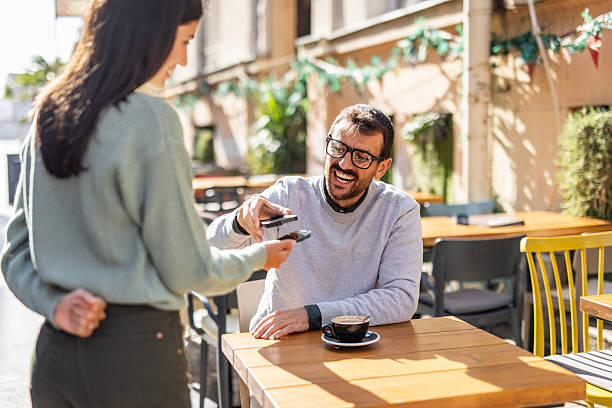 istock Customer making contactless payment with smartphone in outdoor cafe 2232136372