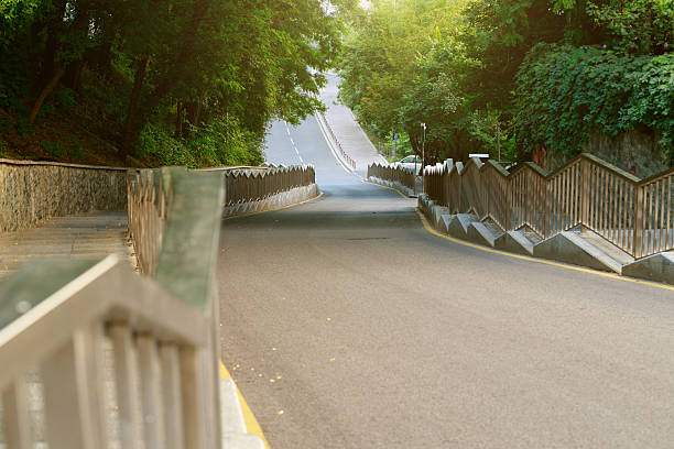 empty road down path asphalt curved way in the city landscaped outskirts environment tunnel natural frame morning sun rise lighting