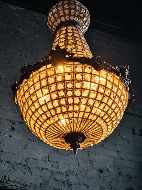 istock Old chandelier in a loft interior with dark grey walls. 2232141341