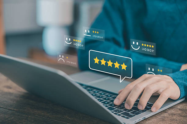 istock online rating system with customer feedback shown as five star reviews and emoticon faces, user typing on laptop to evaluate digital service quality and experience. Business satisfaction concept 2232142050