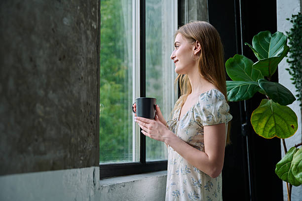 istock Young beautiful dreaming romantic girl looking out the window 2232143694