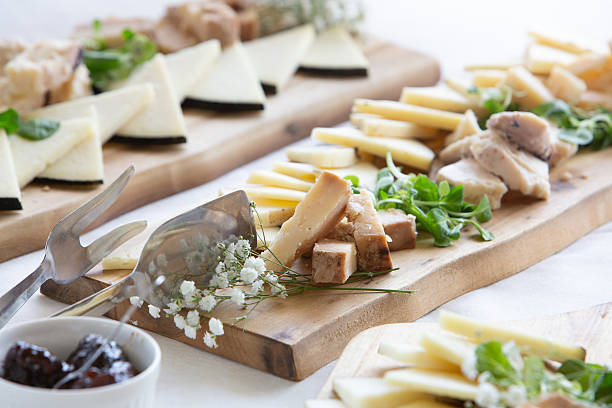 istock Cheese selection platter with serving utensils and garnish on wooden boards 2232144276