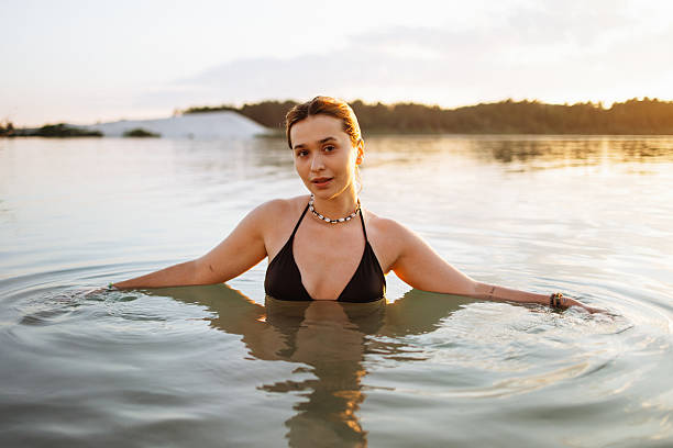 istock Young Woman Relaxing in a Calm Lake During Sunset 2232144954