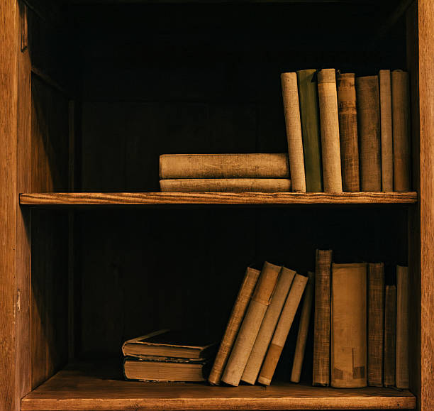 istock Vintage books on a wooden shelf in dim light 2232145632