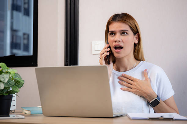 istock Young caucasian businesswoman working on laptop computer while talking on smartphone with stress and upset in office, business woman talking on smart phone with frustrated, business and expression. 2232146161