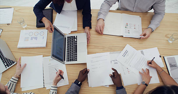 istock Business hands, group and laptop with paperwork for campaign stats, KPI performance and teamwork. Above, people and graph screen in office for research strategy, data analysis or marketing management 2232146638